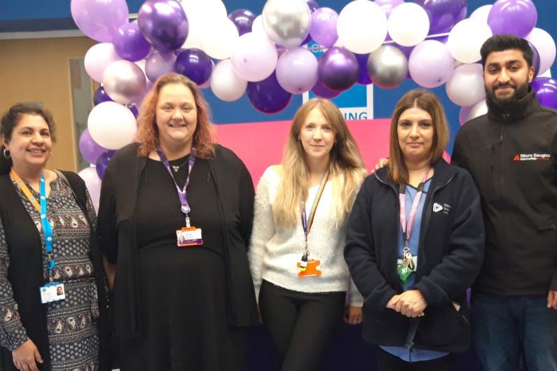 A group of people at our Reading service, standing in front of a balloon arch